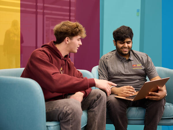 Two male students working on computer